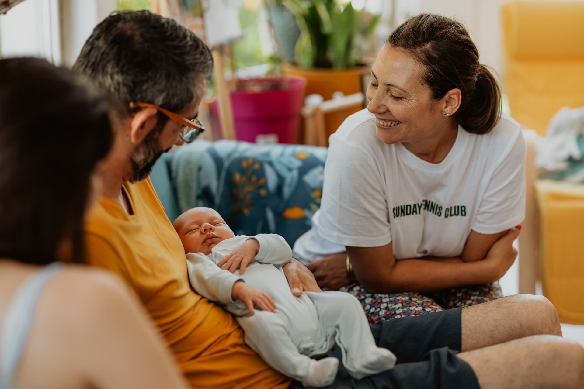 Une doula qui discute avec un jeune papa lors d'une visite postnatale à domicile